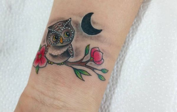 Eule Tattoo mit Halbmond und Blumen am Handgelenk
