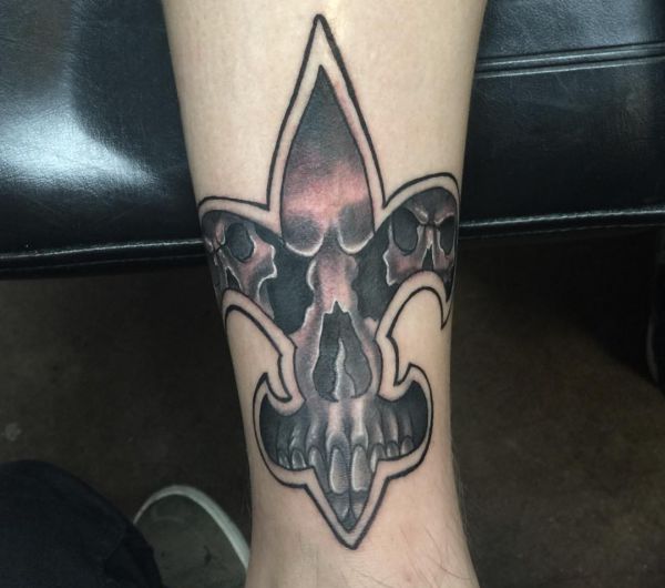 Totenkopf mit Fleur-de-lis Tattoo Design am Unterschenkel