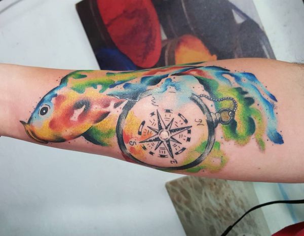 Aquarell Kompass Tattoo mit Vogel am Unterarm