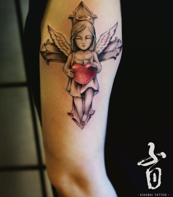 Engel mit Herz und Kreuz Tattoo am Oberarm