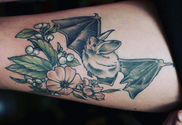 Fledermaus mit Blumen Tattoo am Oberschenkel