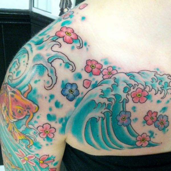 Japanische Wellen Tattoo mit Blumen am Schlüsselbein