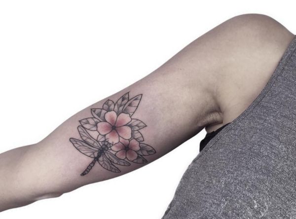 Libelle mit Blumen Tattoo Design am Oberarm