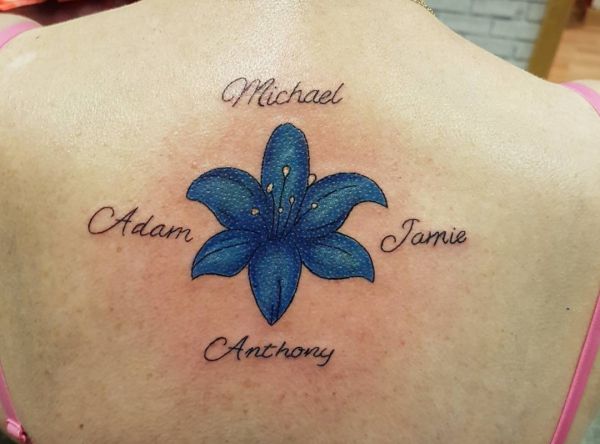 Blaue Lilie mit Namen Tattoo am Rücken