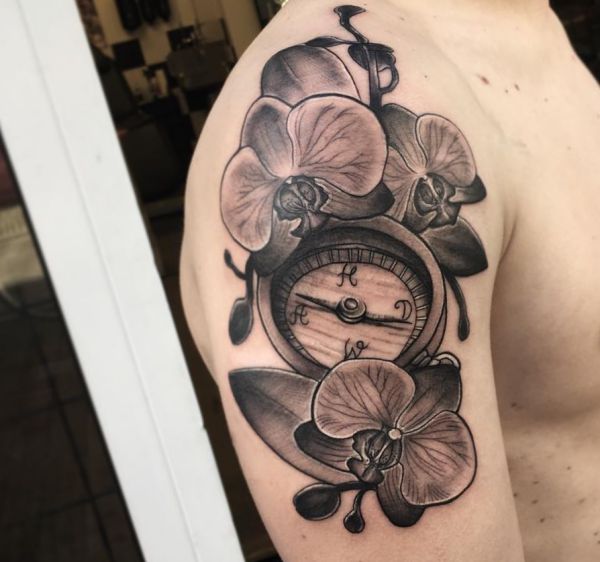 Orchidee Tattoo mit Kompass am Oberarm der Männer