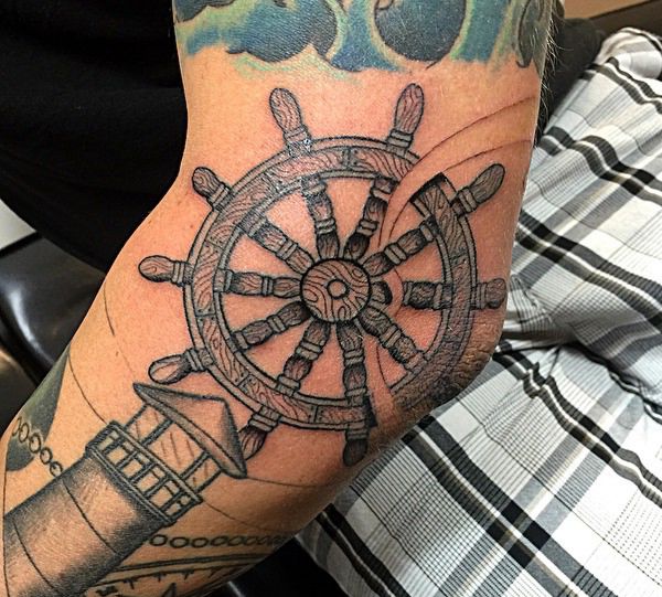 Leuchtturm und Schiffs-Rad auf dem Arm