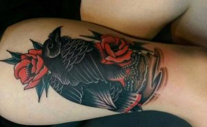Rabe mit Blumen Tattoo am Unterschenkel Frau