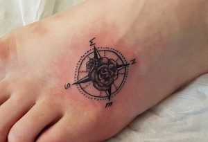 Kleine Kompass Tattoo mit Blume am fuß