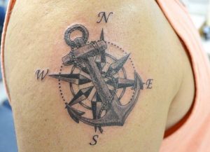 Nautischer Kompass mit Anker am Oberarm