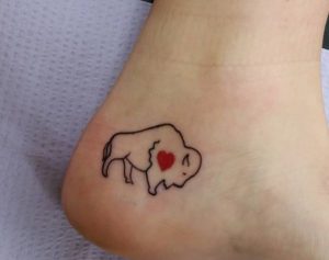 Kleiner Büffel mit Herz Tattoo Design am Knöchel