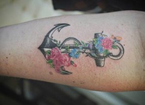 Anker Tattoo mit Blumen am Unterarm