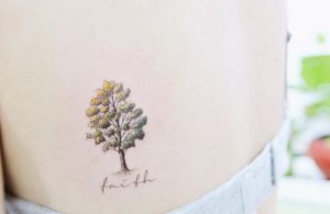 Kleiner Baum mit Namen Tattoo am Schulterblatt