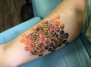 Honigbienen mit Bienenwabe am Unterarm
