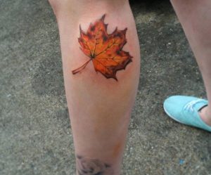 Gelbe Blätter Tattoo am Unterschenkel