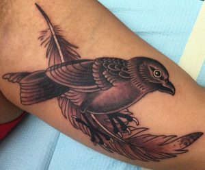 Feder mit Vogel auf dem Arm