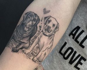 Zwei Hunde mit Herz am Unterarm schwarz und weiß