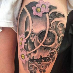 Japanischer Totenkopf und Blumen Tattoo Design am Oberschenkel