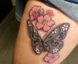 Spitze Schmetterling und Kirschblüten Tattoo am Oberschenkel