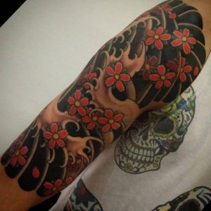 Wellen und Kirschblüten Tattoo auf dem Arm