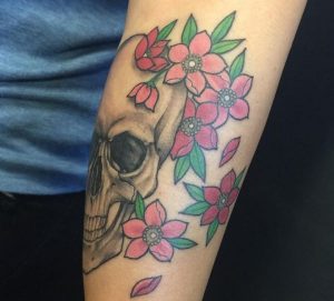 Kirschblüten und Totenkopf Tattoo am Unterarm