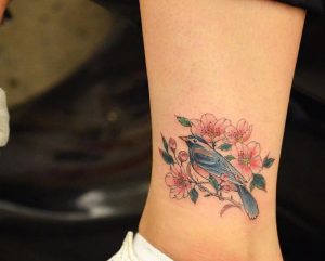 Kirschblüten und Vogel Tattoo am Knöchel