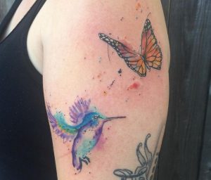Kolibri und Schmetterling am Oberarm