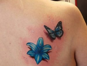 Blaue Lilie und Schmetterling Tattoo am Rücken