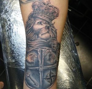 Löwe mit Krone Tattoo auf dem Arm