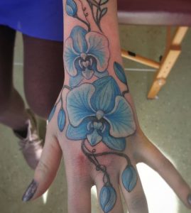 Lila Orchidee Tattoo auf der Hand für Frauen