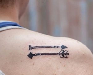 Zwei Pfeile in entgegengesetzte Richtungen Tattoo Design am Schulterblatt