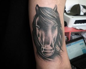 Pferdekopf Tattoo Design am Oberarm Schwarz