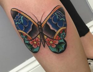 Schmetterling mit Blumen Tattoo am Unterschenkel