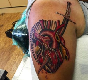 Schwert Tattoo mit Herz auf dem Arm
