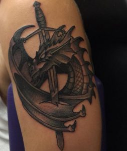 Schwert Tattoo mit Drache am Oberarm