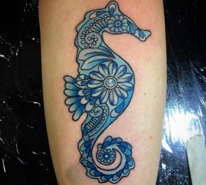 Blaue Seepferdchen mit Blume auf der Bein