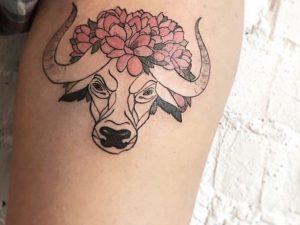 Tattoo Stierkopf mit Blumen Design am Oberarm für Frauen