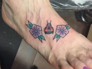Marienkäfer mit Blumen Tattoo Design am fuß