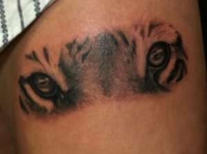 Tigeraugen Tattoo am Oberschenkel